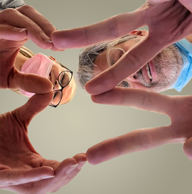 Foto, zwei Menschen die mit Ihren Händen einen Zahn darstellen